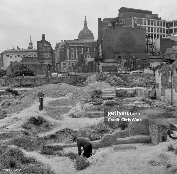 Archaeologists excavate an archaeological site, showing sections of Roman walls being unearthed at Windsor Court, Cripplegate, with the dome of St...