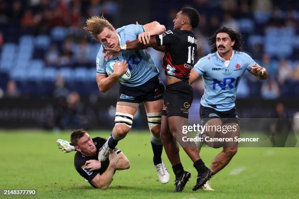 Ned Hanigan of the NSW Waratahs is tackled by Dallas McLeod of the Crusaders and Sevu Reece of the Crusaders during the round eight Super Rugby...