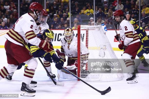 Jacob Fowler of the Boston College Eagles watches as Dylan Duke of the Michigan Wolverines reaches for the puck in the second period during the...