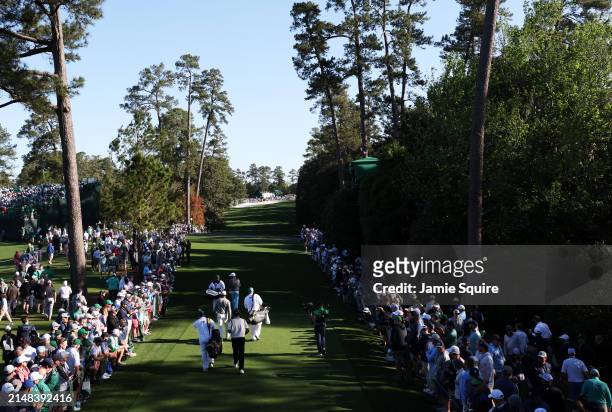 Tiger Woods of the United States, Jason Day of Australia and Max Homa of the United States walk off the 18th tee during the continuation of the first...