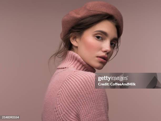 beautiful sensual girl in a sweater and beret - roze hoed stockfoto's en -beelden
