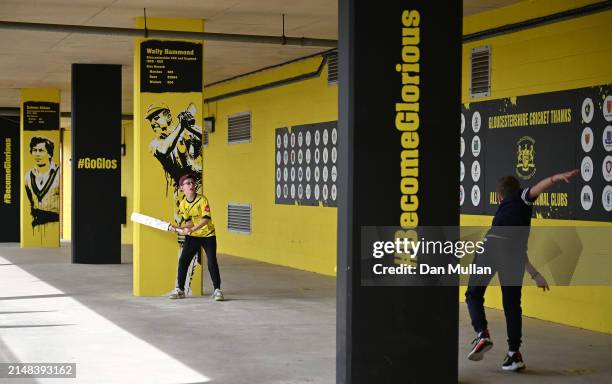 Two young supporters play cricket behind the grandstand during day one of the Vitality County Championship match between Gloucestershire and...