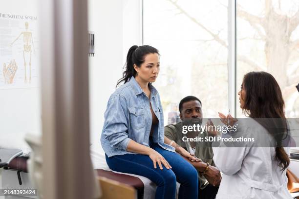 female doctor holds syringe and vial to give instructions - spoedeisende geneeskunde stockfoto's en -beelden