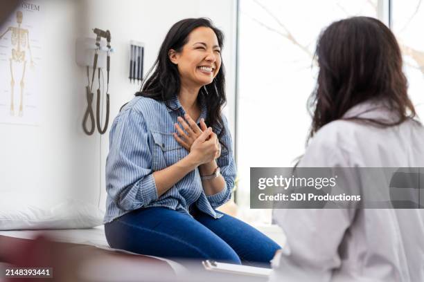 mid adult female is excited to hear about her test results - boa notícia imagens e fotografias de stock