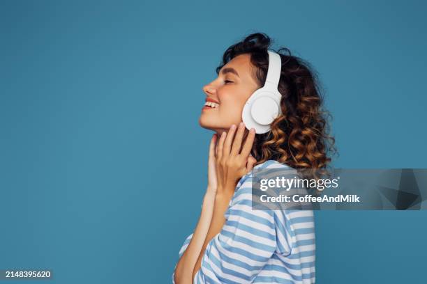 schöne emotionale frau, die musik hört - kopfhörer freisteller stock-fotos und bilder