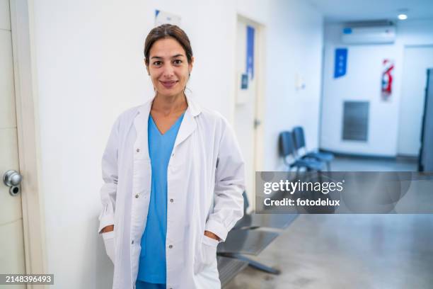 confident female doctor standing in hospital corridor - hospital environment stock pictures, royalty-free photos & images