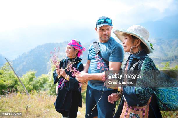european male tourist talking to two indigenous woman in sa pa, vietnam