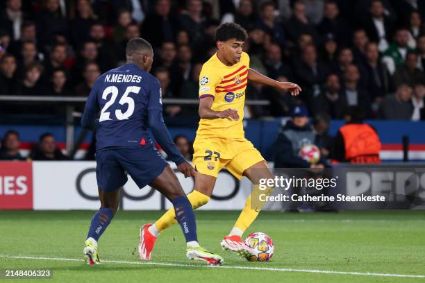 Lamine Yamal of FC Barcelona controls the ball against Nuno Mendes of Paris Saint-Germain during the UEFA Champions League quarter-final first leg...