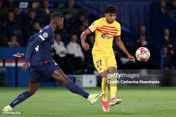 Lamine Yamal of FC Barcelona shoots the ball against Nuno Mendes of Paris Saint-Germain during the UEFA Champions League quarter-final first leg...