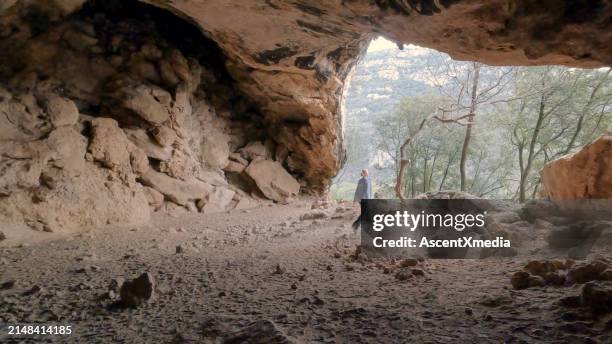 mature woman hikes through cave - finale ligure stock pictures, royalty-free photos & images