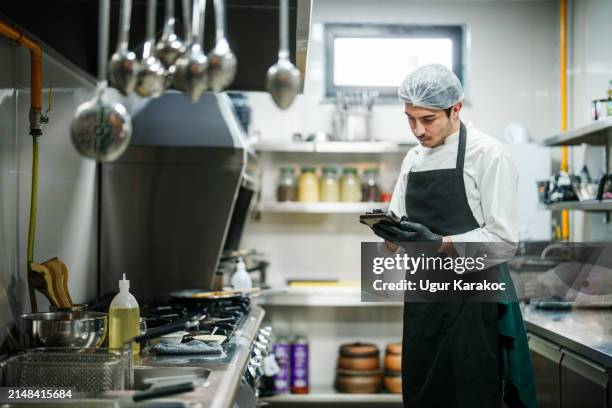 chef using digital tablet in a restaurant kitchen. - cooking utensil stock pictures, royalty-free photos & images