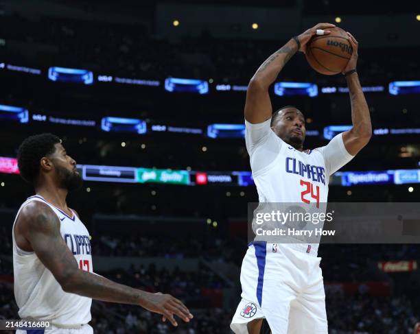 Norman Powell of the LA Clippers grabs a rebound in front of Paul George during a 120-118 Clippers win over the Cleveland Cavaliers at Crypto.com...