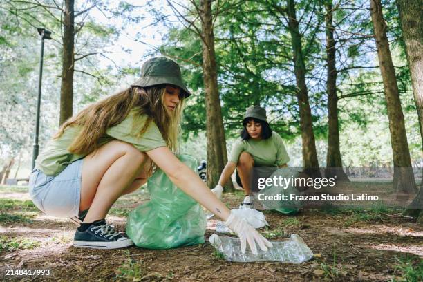 friends collecting trash in public park - clear bin bag stock pictures, royalty-free photos & images