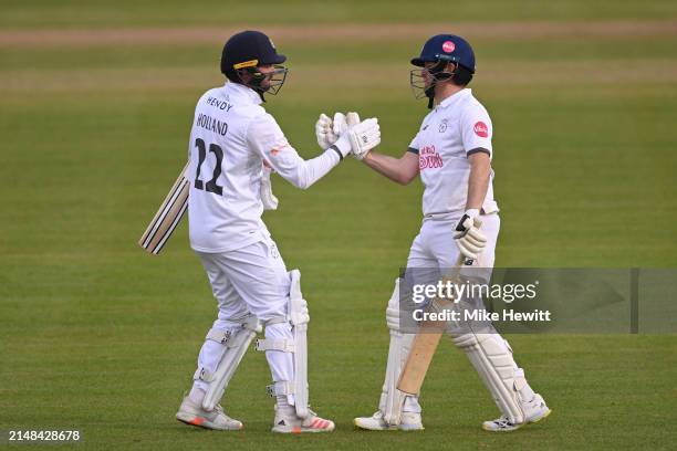 Liam Dawson of Hampshire celebrates with batting partner Ian Holland afterreaching his 50 during the Vitality County Championship Division One match...
