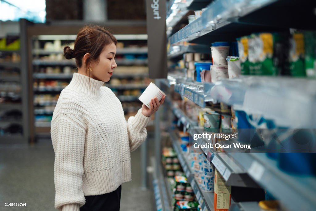Young Asian woman shopping dairy foods in supermarket