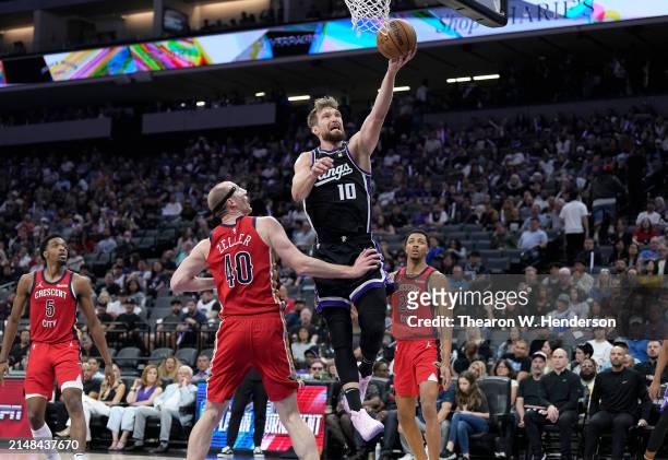 Domantas Sabonis of the Sacramento Kings shoots over Cody Zeller of the New Orleans Pelicans during the second half of an NBA basketball game at...