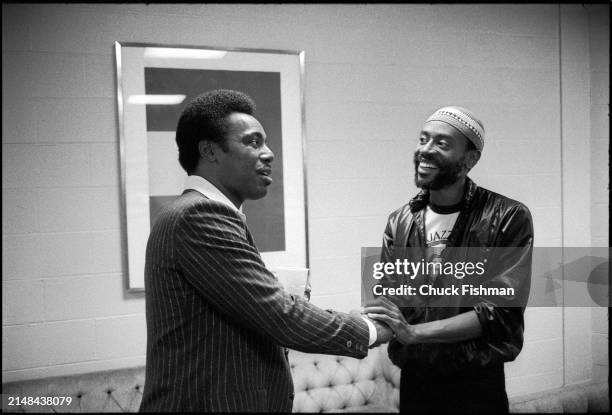 View of American Jazz musicians George Benson and Bobby McFerrin shake hands backstage during at Kool Jazz Festival, Saratoga Springs, New York,...