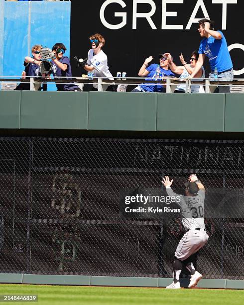 Fan catches a home run ball hit by MJ Melendez of the Kansas City Royals as Robbie Grossman of the Chicago White Sox looks on during the seventh...