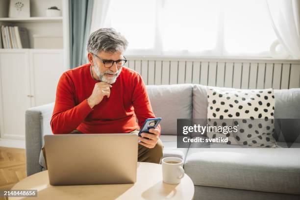 mature man working from home - red computer stock pictures, royalty-free photos & images