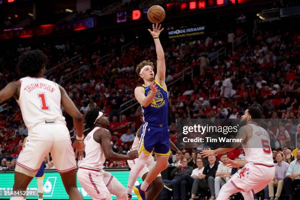 Brandin Podziemski of the Golden State Warriors shoots the ball between Aaron Holiday of the Houston Rockets and Fred VanVleet in the second half at...