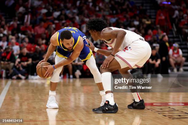 Stephen Curry of the Golden State Warriors controls the ball while defended by Amen Thompson of the Houston Rockets in the second half at Toyota...