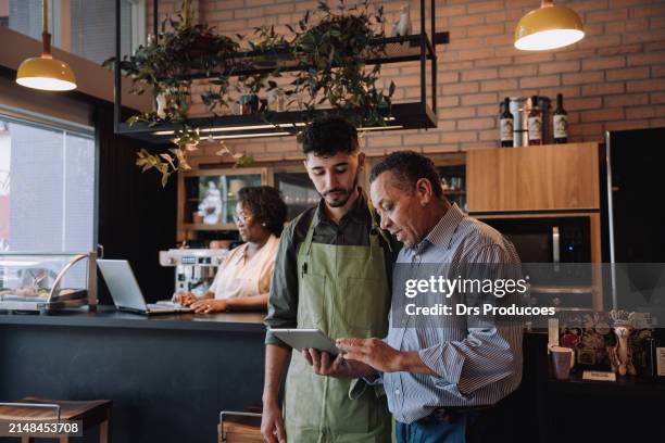 el dueño de una cafetería habla con el empleado - pequeña empresa fotografías e imágenes de stock