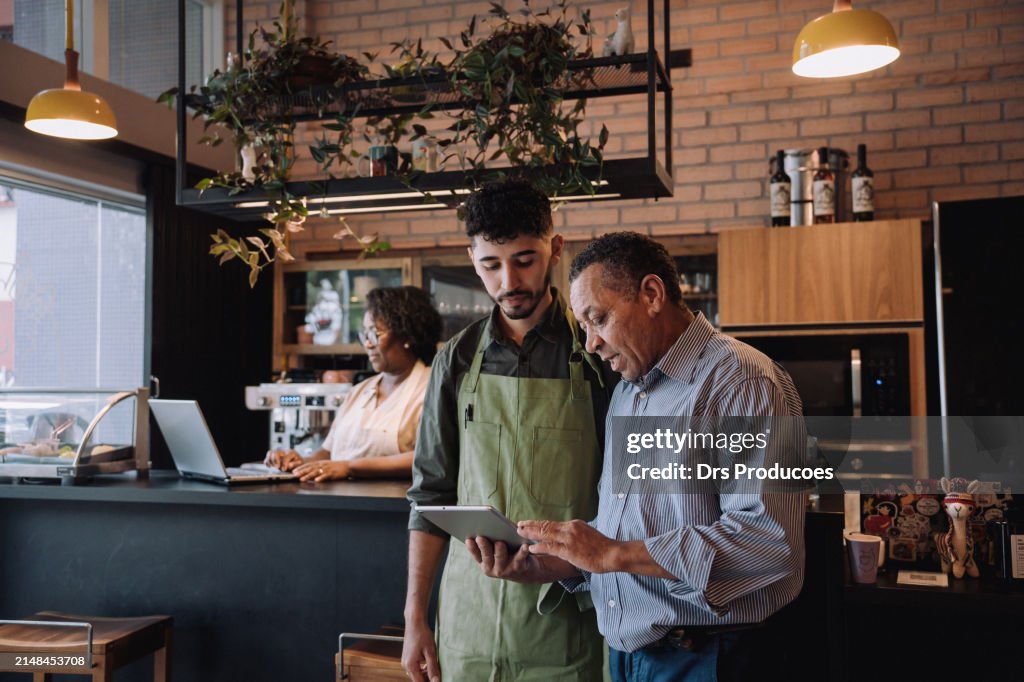 Coffee shop owner talking to employee
