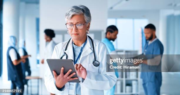 mature woman, thinking or doctor on tablet at hospital for healthcare questions, research or schedule solution. digital, app or surgeon brainstorming at clinic for telehealth problem solving or faq - doctor reading results stock pictures, royalty-free photos & images