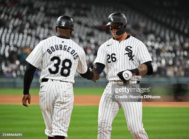Korey Lee of the Chicago White Sox is congratulated by third base coach Jason Bourgeois of the Chicago White Sox following a single during the fifth...
