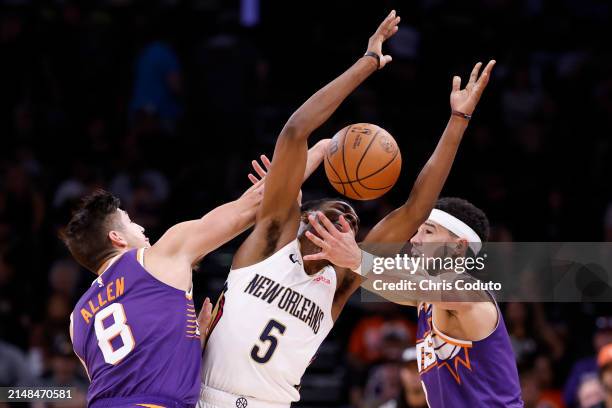 Grayson Allen and Devin Booker of the Phoenix Suns pressure Herbert Jones of the New Orleans Pelicans during the second half at Footprint Center on...