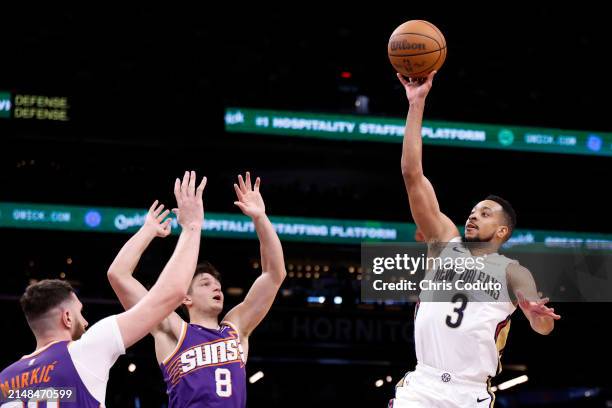 McCollum of the New Orleans Pelicans attempts a shot over Grayson Allen and Jusuf Nurkic of the Phoenix Suns during the game at Footprint Center on...