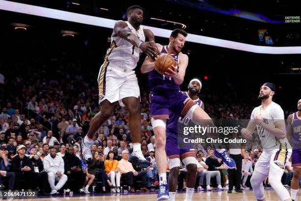 Zion Williamson of the New Orleans Pelicans and Drew Eubanks of the Phoenix Suns battle for a rebound during the game at Footprint Center on April...