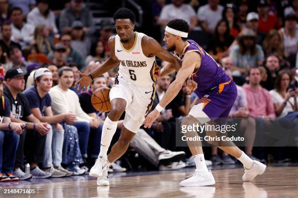 Devin Booker of the Phoenix Suns steals the ball from Herbert Jones of the New Orleans Pelicans during the game at Footprint Center on April 07, 2024...