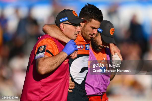 Stephen Coniglio of the Giants is carried off the ground during the round five AFL match between Greater Western Sydney Giants and St Kilda Saints at...