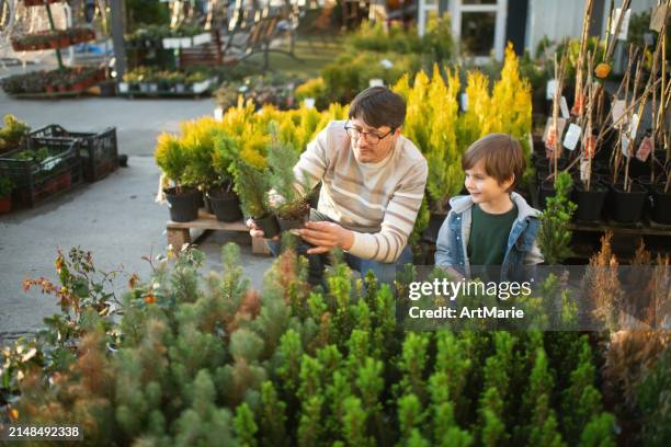 family choosing plants in a local garden center - nationale-boomfeestdag stockfoto's en -beelden