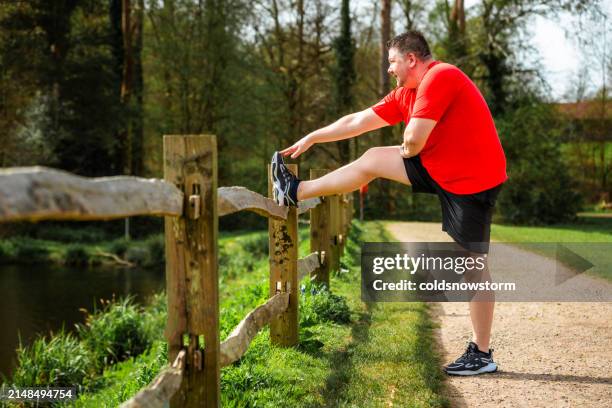 mid adult man stretching hamstring muscles before running - stretching hamstring stock pictures, royalty-free photos & images