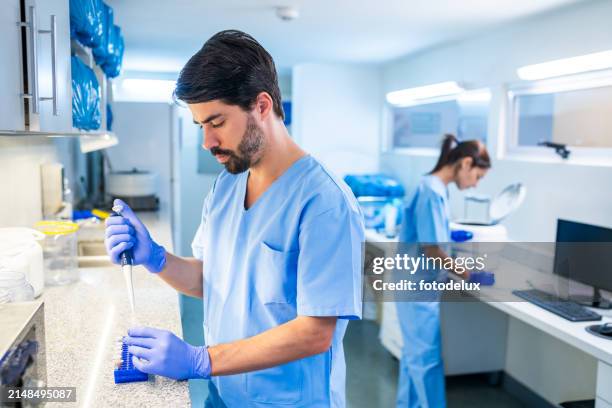 male scientist using pipette in laboratory research setting - pipette stock pictures, royalty-free photos & images