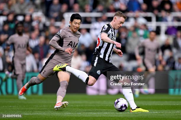 Sean Longstaff of Newcastle United runs with the ball whilst under pressure from Son Heung-Min of Tottenham Hotspur during the Premier League match...