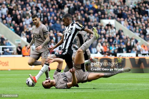 Alexander Isak of Newcastle United scores his team's first goal as Micky van de Ven of Tottenham Hotspur goes down during the Premier League match...
