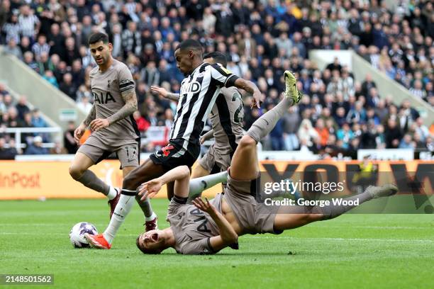 Alexander Isak of Newcastle United scores his team's first goal as Micky van de Ven of Tottenham Hotspur goes down during the Premier League match...