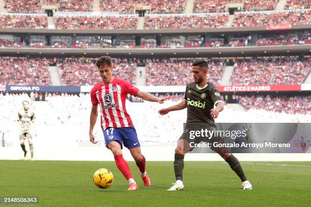 Rodrigo Riquelme of Atletico Madrid runs with the ball under pressure from Yan Couto of Girona FC during the LaLiga EA Sports match between Atletico...