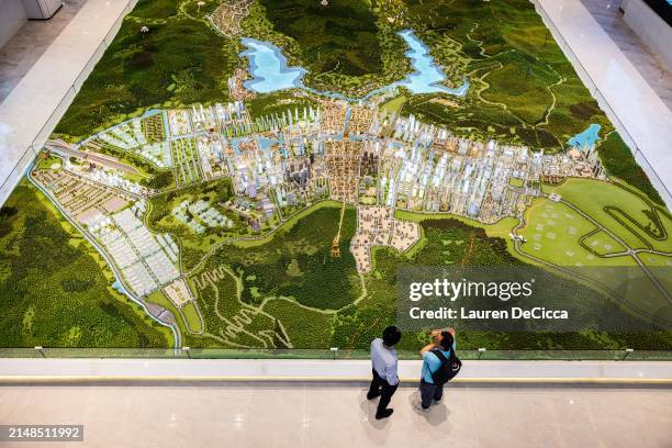 Potential buyers look at a model of the planned completion of the Boten Special Economic Zone on April 10, 2024 in Boten, Laos. The Boten Special...