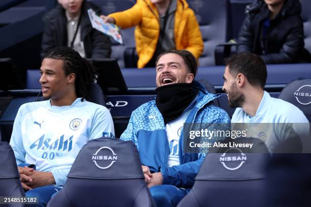 Jack Grealish of Manchester City reacts alongside Nathan Ake and Bernardo Silva on the substitutes bench during the Premier League match between...
