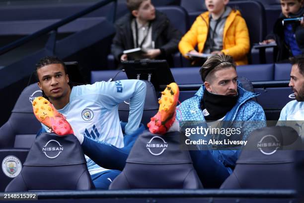 Nathan Ake, Jack Grealish and Bernardo Silva of Manchester City interact on the substitutes bench during the Premier League match between Manchester...