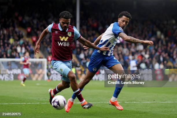 Lyle Foster of Burnley is tackled by Joao Pedro of Brighton & Hove Albion during the Premier League match between Burnley FC and Brighton & Hove...