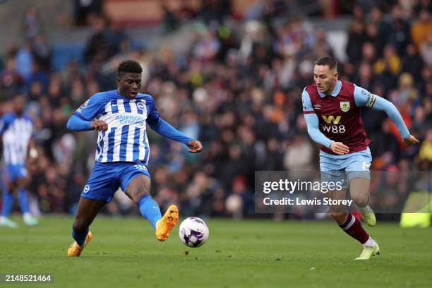 Carlos Baleba of Brighton & Hove Albion passes the ball past Josh Brownhill of Burnley during the Premier League match between Burnley FC and...