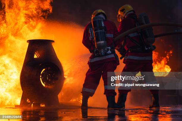 firefighters' nighttime fire suppression training by simulating fire control in industrial plants with gas pipelines or oil pipelines, conducted by a teamwork. - conducted stock pictures, royalty-free photos & images