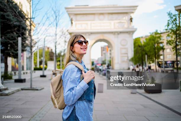 woman in front of triumphal arch in skopje - skopje stock pictures, royalty-free photos & images