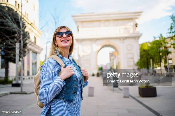 woman in front of triumphal arch in skopje - skopje stock pictures, royalty-free photos & images