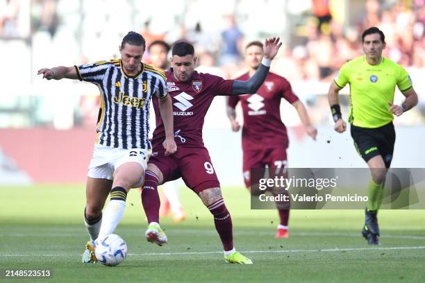 Adrien Rabiot of Juventus is challenged by Antonio Sanabria of Torino FC during the Serie A TIM match between Torino FC and Juventus at Stadio...